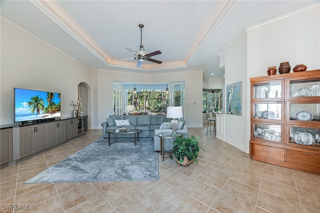 living room featuring crown molding, ceiling fan, a raised ceiling, and light tile patterned floors