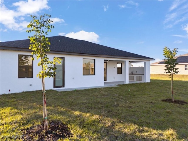 back of property featuring a patio and a yard