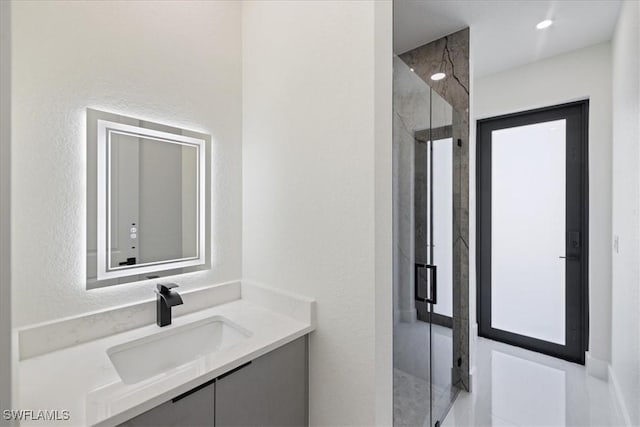 bathroom featuring vanity and a shower with door