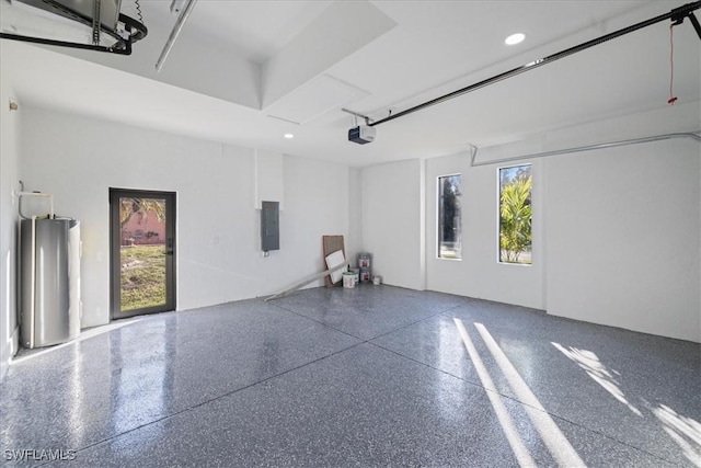 garage with water heater, a garage door opener, and electric panel