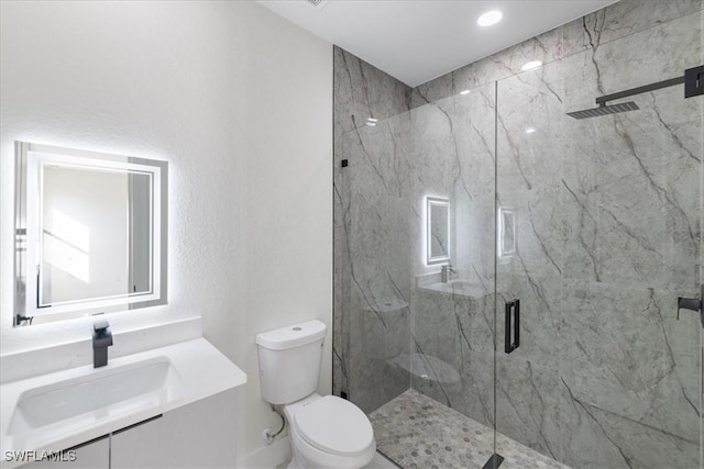 bathroom with vanity, a shower with shower door, and toilet