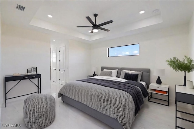 bedroom with a raised ceiling and ceiling fan