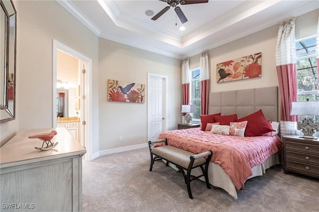 bedroom with light carpet, baseboards, ensuite bath, a tray ceiling, and crown molding