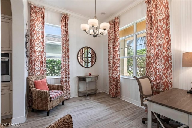 office space with light wood-style floors, a healthy amount of sunlight, baseboards, and an inviting chandelier