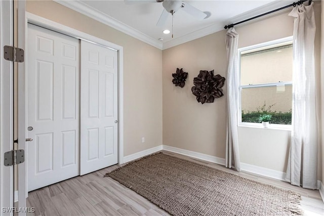 unfurnished bedroom featuring ceiling fan, baseboards, ornamental molding, a closet, and light wood finished floors