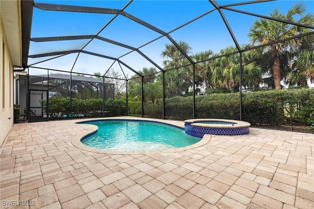 view of swimming pool featuring a lanai, a patio area, and a pool with connected hot tub