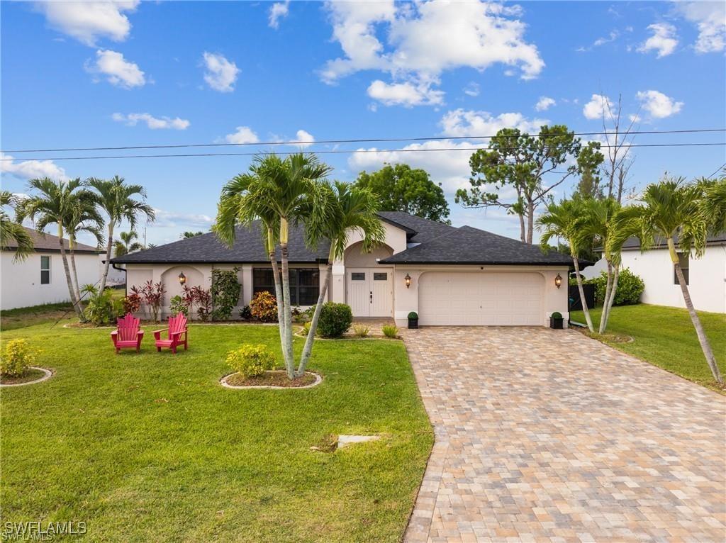 single story home featuring a garage and a front lawn