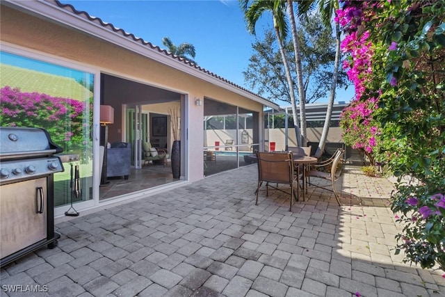 view of patio with a lanai and a grill