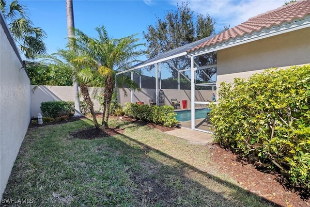 view of yard featuring a fenced in pool and glass enclosure