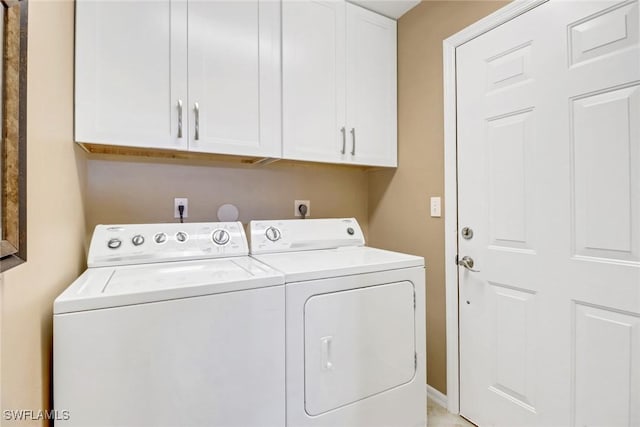 washroom featuring washer and clothes dryer and cabinets