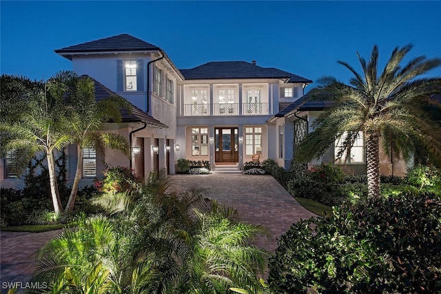 view of front of home with a balcony and french doors