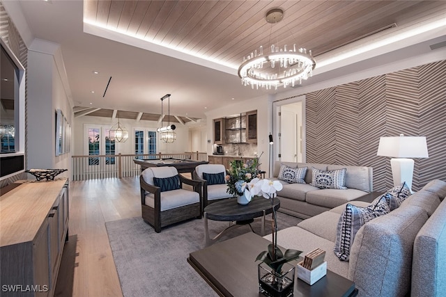 living room featuring light hardwood / wood-style flooring, wood ceiling, a chandelier, and a tray ceiling