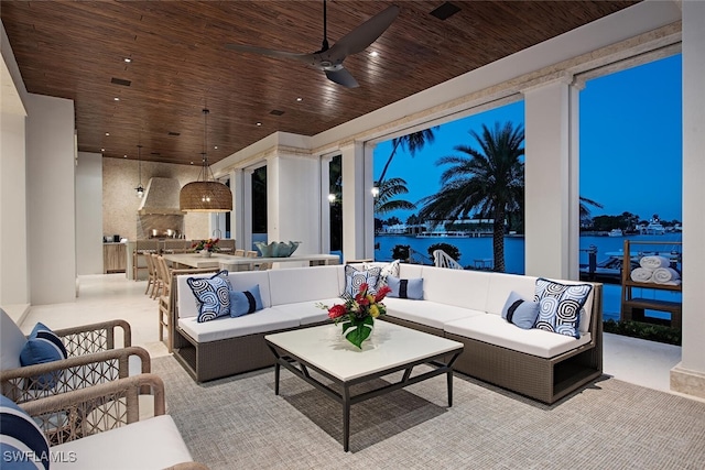 interior space featuring an outdoor living space, a water view, an outdoor kitchen, and ceiling fan