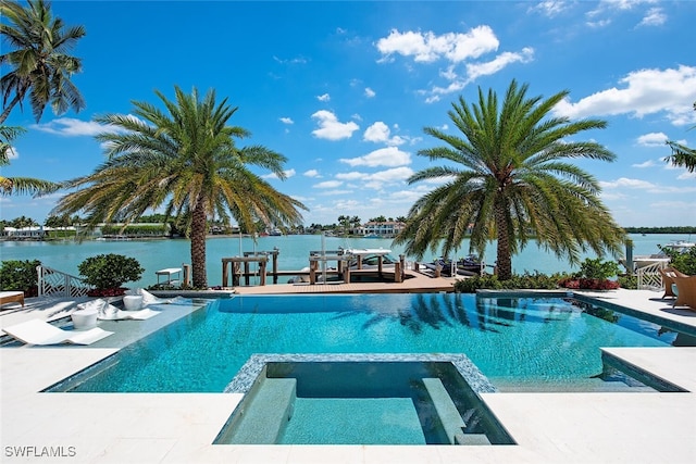 view of swimming pool featuring an in ground hot tub and a water view