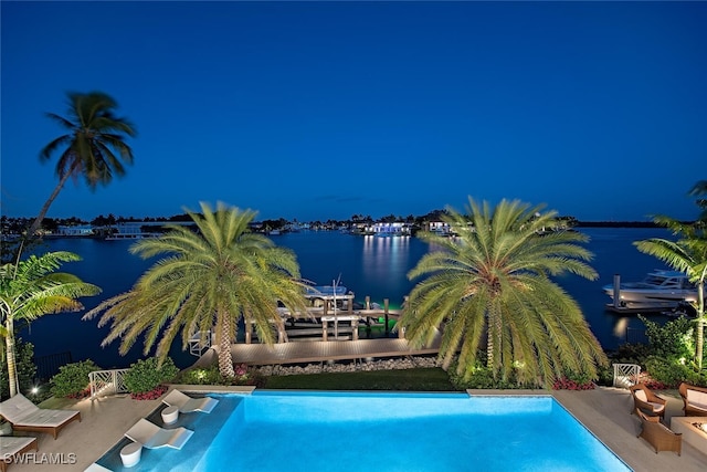 view of pool featuring a patio area and a water view