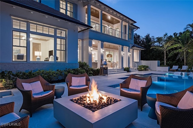 patio terrace at dusk featuring a fire pit