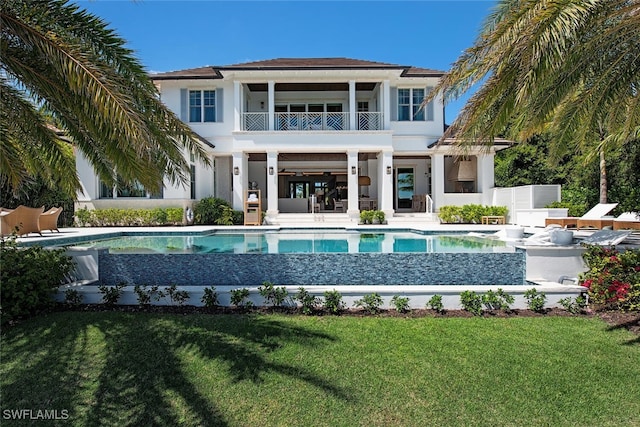 back of property featuring a patio, a balcony, and a lawn