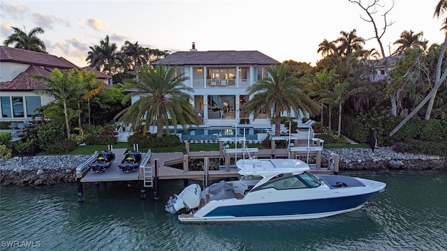 view of dock with a balcony and a water view