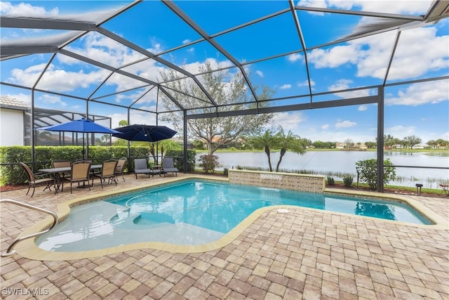 view of pool with a patio area, a water view, pool water feature, and glass enclosure