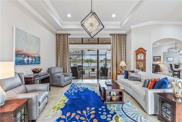 living room with ornamental molding, a raised ceiling, and a high ceiling