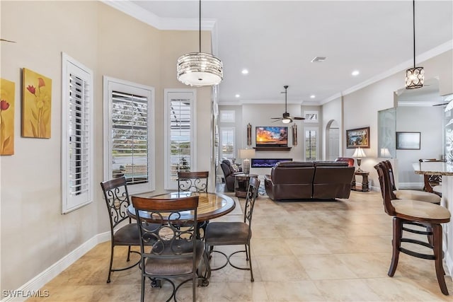 dining room featuring light tile patterned floors, crown molding, ceiling fan, and a high ceiling