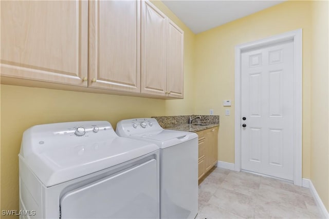 washroom with cabinets, sink, and washing machine and dryer