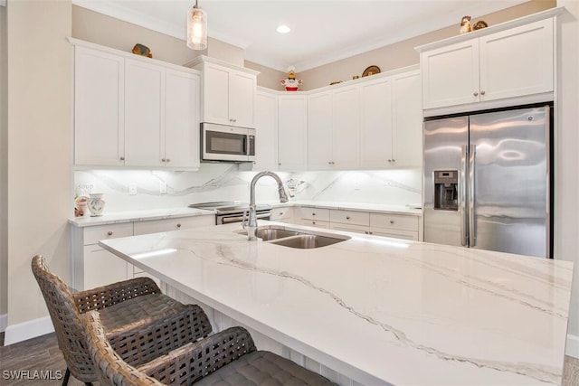 kitchen featuring sink, white cabinetry, backsplash, stainless steel appliances, and decorative light fixtures