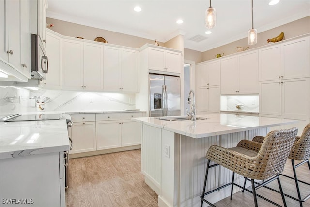 kitchen with appliances with stainless steel finishes, sink, and an island with sink