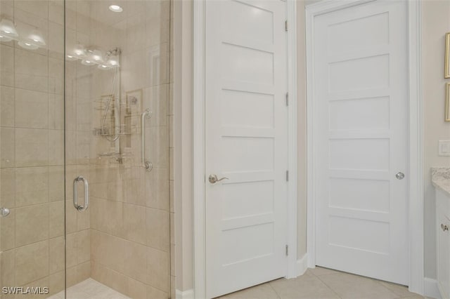 bathroom with an enclosed shower, vanity, and tile patterned floors