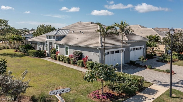 ranch-style house featuring a garage and a front lawn