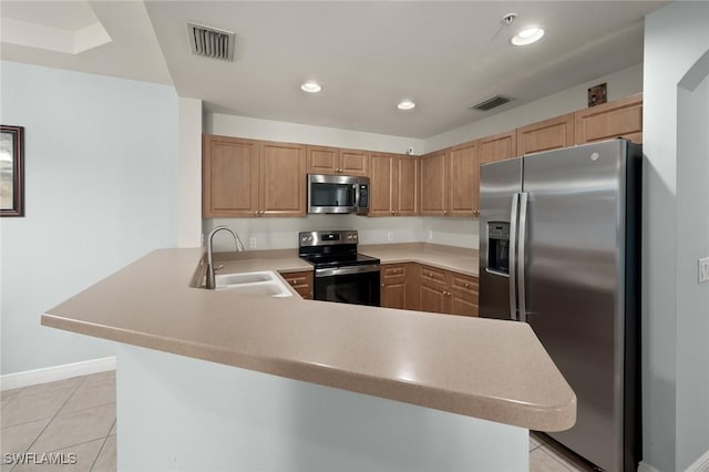 kitchen with sink, light brown cabinets, light tile patterned floors, appliances with stainless steel finishes, and kitchen peninsula