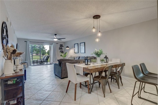 dining space featuring light tile patterned floors, ceiling fan, and a textured ceiling