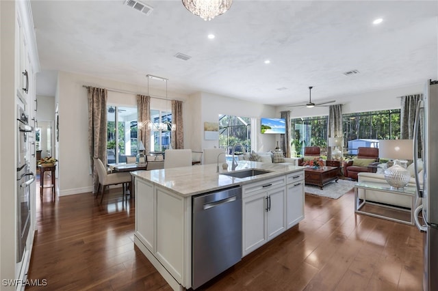 kitchen featuring white cabinetry, sink, a kitchen island with sink, light stone counters, and stainless steel appliances