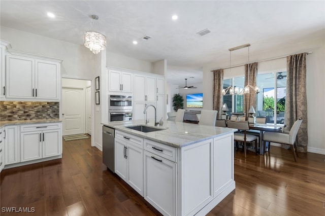 kitchen featuring stainless steel appliances, white cabinetry, sink, and decorative light fixtures