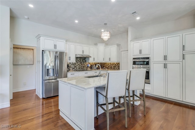 kitchen with a kitchen island with sink, sink, stainless steel appliances, and white cabinets