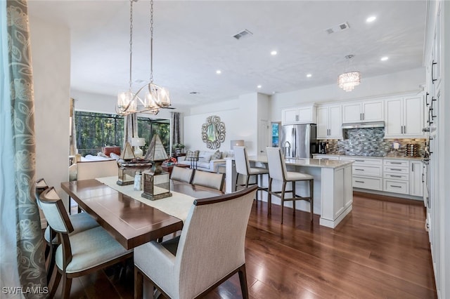 dining area with an inviting chandelier and dark wood-type flooring