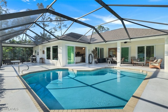 view of swimming pool with ceiling fan, a grill, a lanai, and a patio area