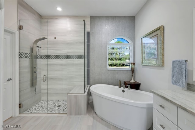 bathroom featuring vanity and independent shower and bath