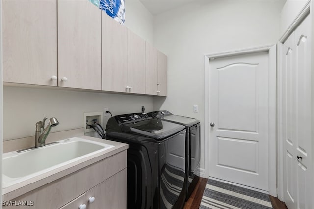 laundry room with cabinets, dark hardwood / wood-style flooring, sink, and washing machine and clothes dryer