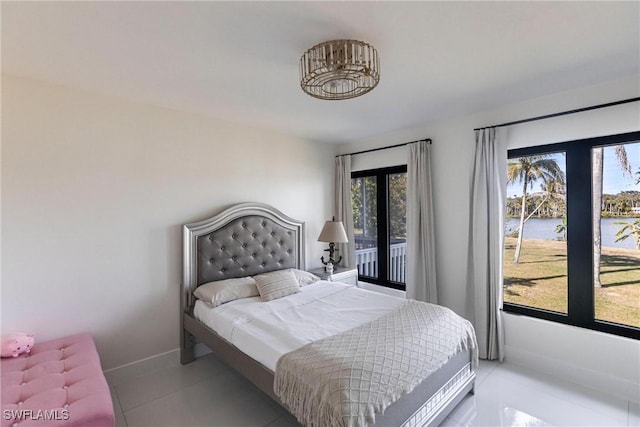 bedroom with a water view and tile patterned floors