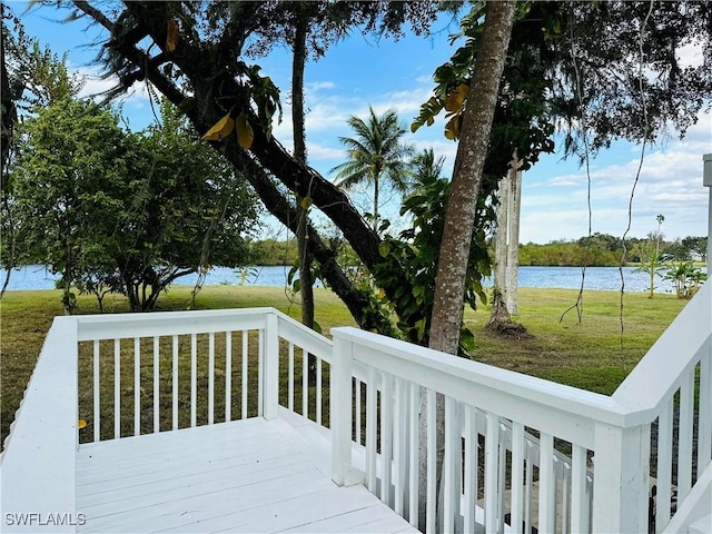 deck with a lawn and a water view