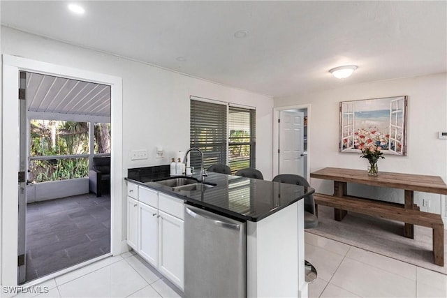 kitchen featuring light tile patterned flooring, sink, white cabinetry, dishwasher, and kitchen peninsula