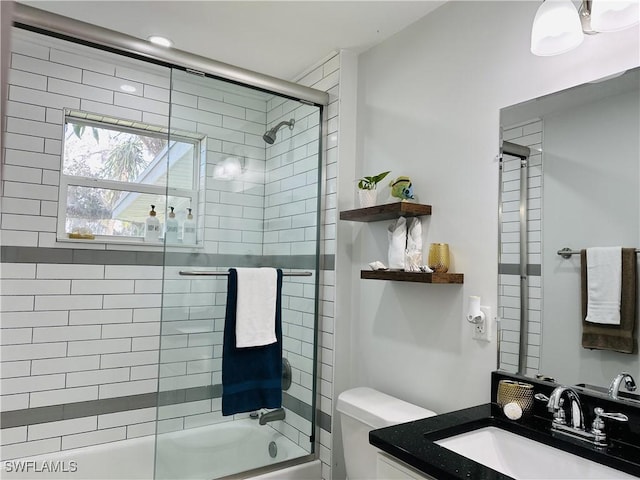 full bathroom featuring vanity, enclosed tub / shower combo, and toilet