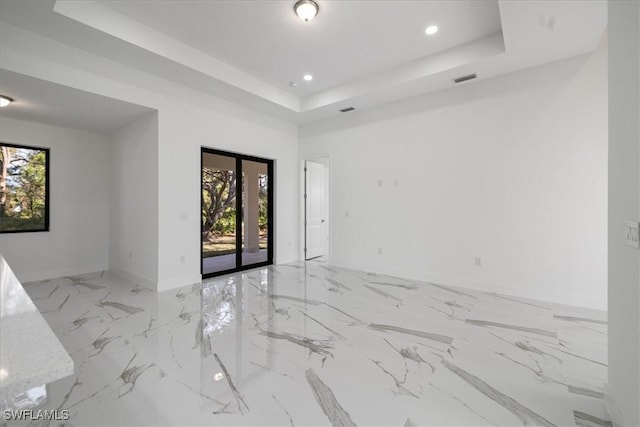 unfurnished room with a raised ceiling and french doors