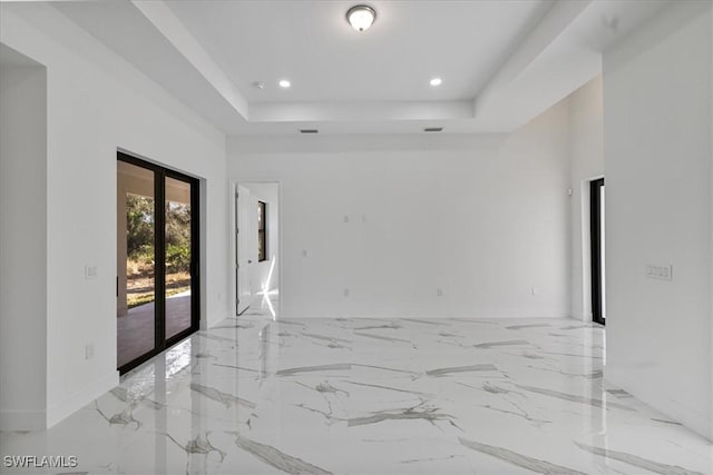 empty room featuring french doors and a tray ceiling