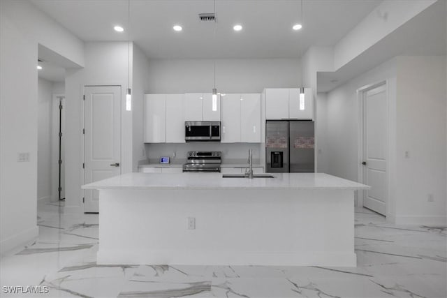 kitchen with sink, pendant lighting, stainless steel appliances, a kitchen island with sink, and white cabinets