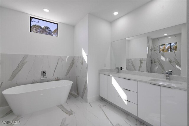 bathroom with a healthy amount of sunlight, vanity, and a tub