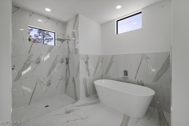 bathroom featuring plenty of natural light and separate shower and tub