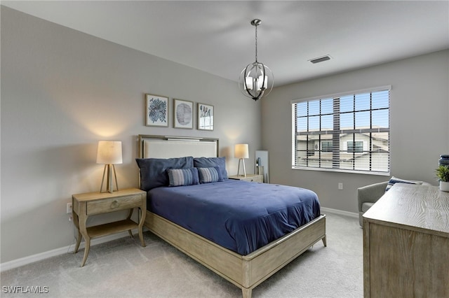 carpeted bedroom featuring an inviting chandelier