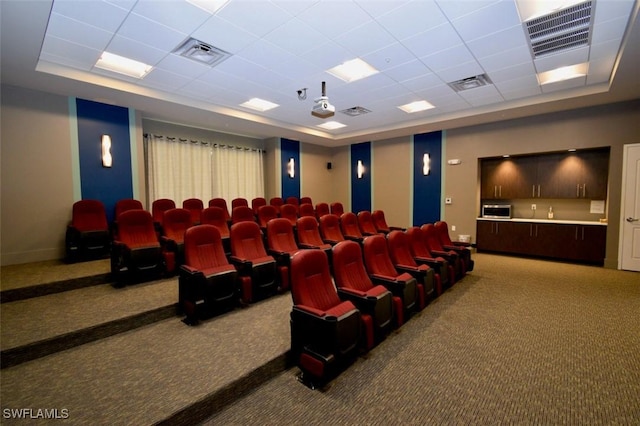 home theater room with a raised ceiling, carpet floors, and a paneled ceiling